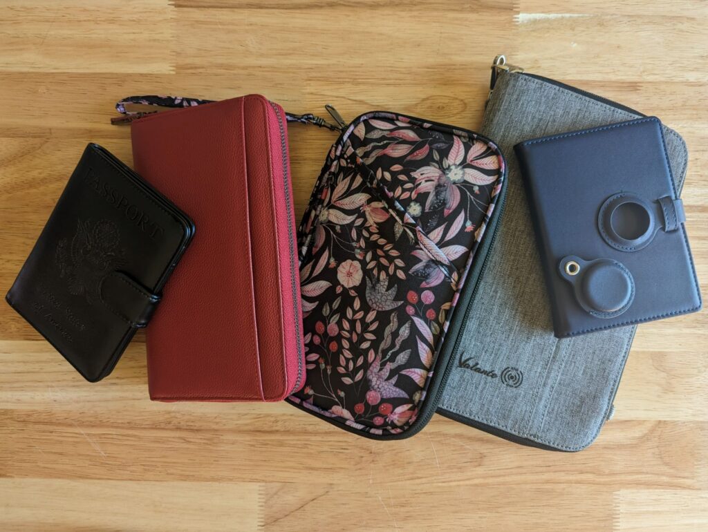 5 travel wallets of various styles on a tabletop