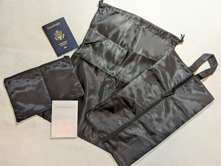 3 of the Veken 8-Set Packing Cubes bags spread out next to a passport and instructions