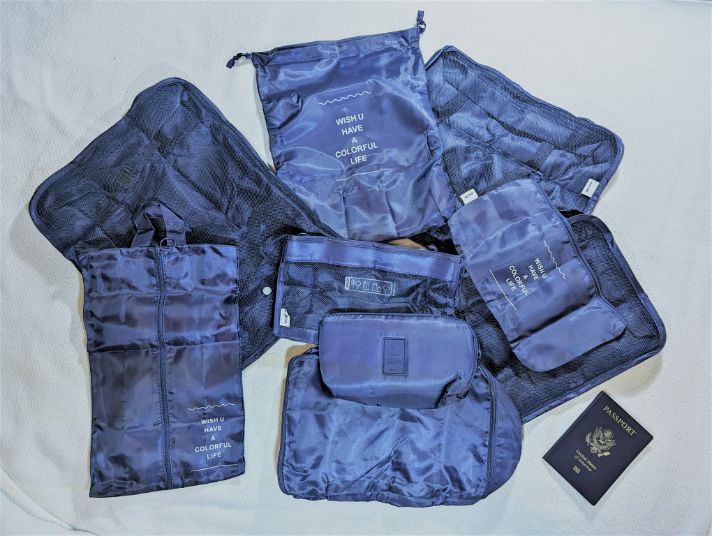 Mossio 9-Set Packing Cubes spread out next to a passport for size comparison