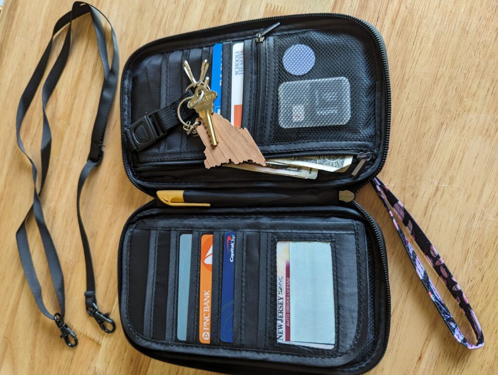 P TRAVEL DESIGN RFID Travel Passport Holder and Wallet open showing cards, keys, sd cards, gps tracker, and pen