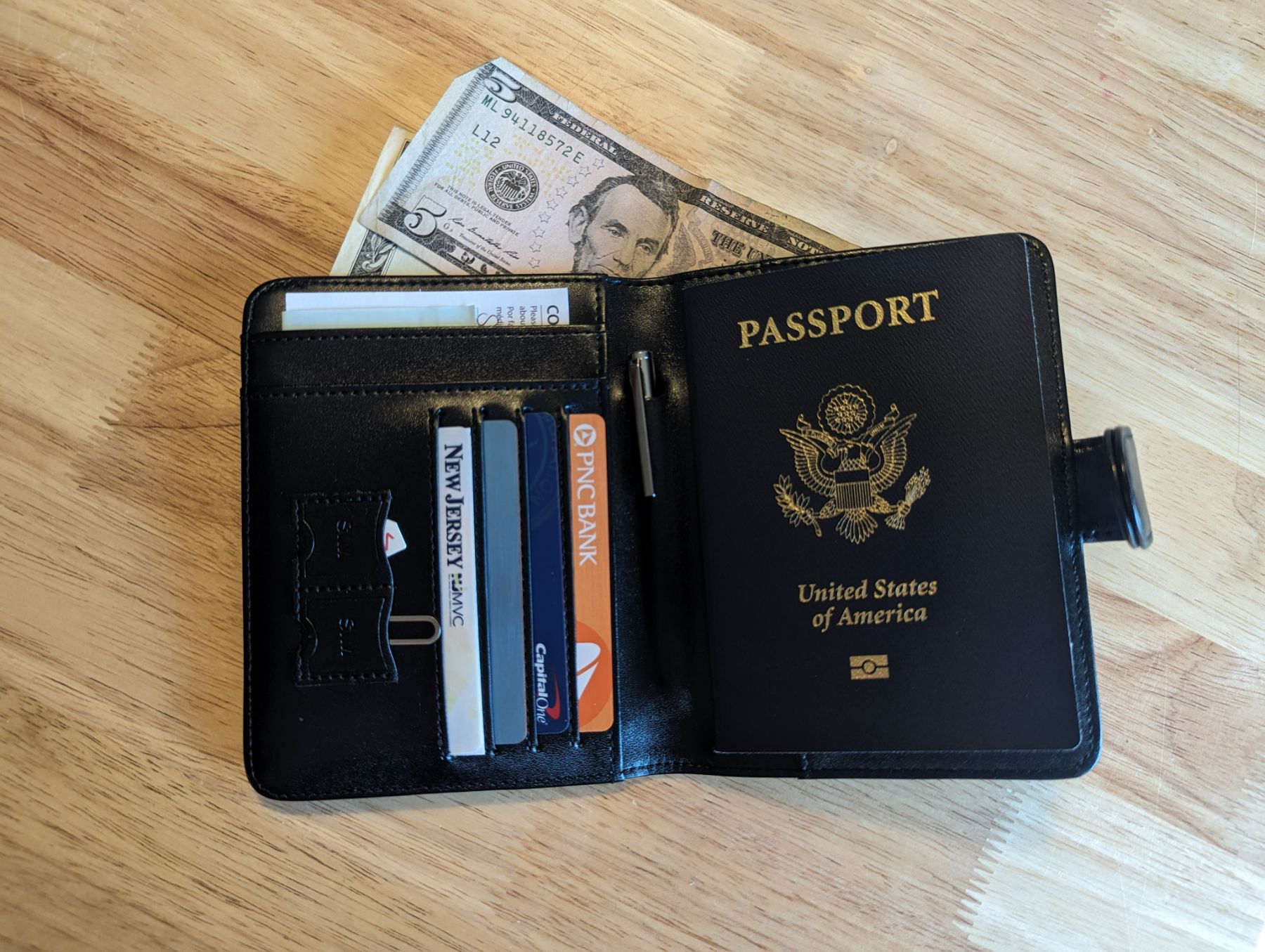 PASCACOO AirTag Passport Holder Wallet open with cash, passport, cards, sim card, and more inside